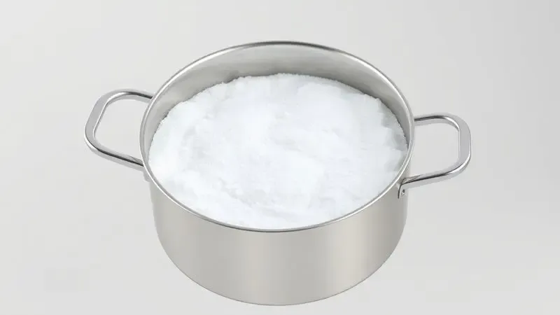 Representação artística de bicarbonato de sódio agindo sobre uma panela de inox para remover queimados.