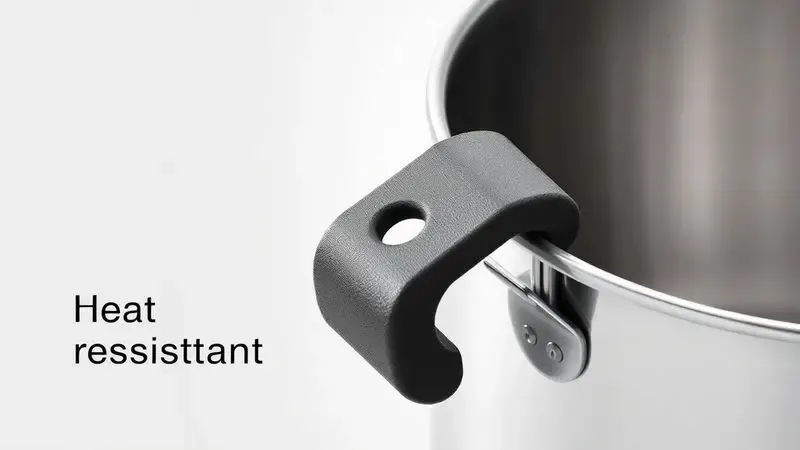 Detalhe de um cabo antitérmico de baquelite focado em segurança e ergonomia na cozinha.