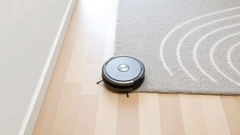 Representação digital de um robô aspirador operando em diferentes superfícies de piso em uma casa limpa.