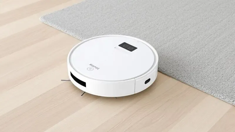 Renderização 3D de robô aspirador limpando diferentes superfícies como madeira e tapete.
