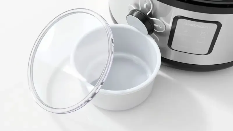 Componentes de uma panela de pressão elétrica limpos e organizados para manutenção.