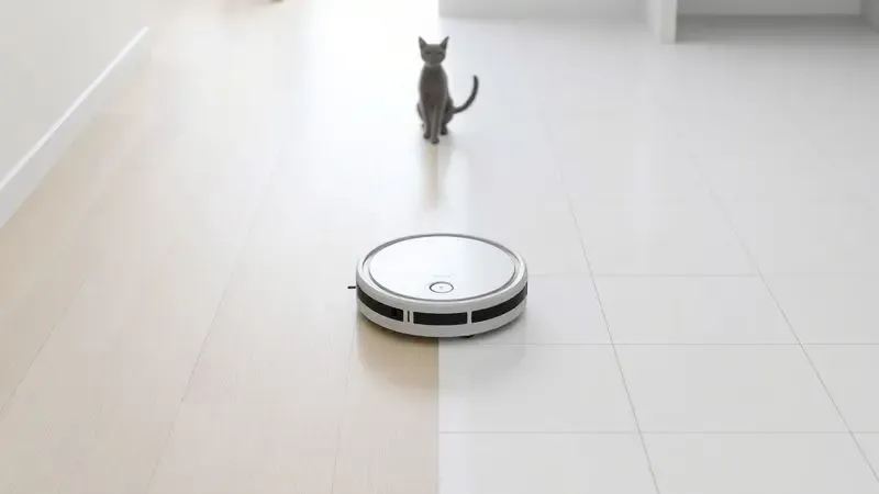 Ilustração de um robô aspirador transitando entre pisos de madeira e cerâmica em uma casa com a presença de um animal de estimação.