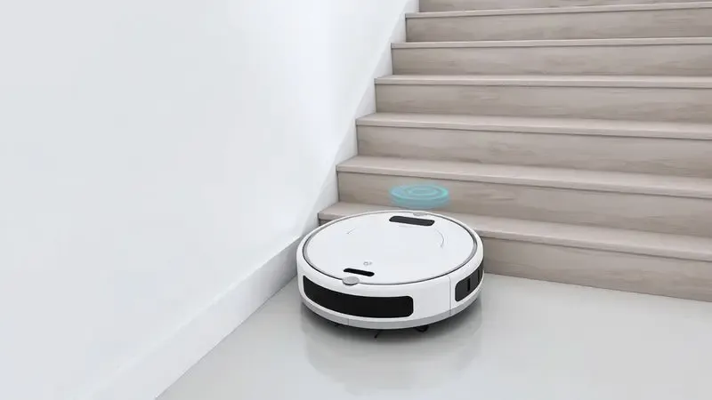 Renderização 3D de um aspirador robô detectando a borda de uma escada com seus sensores de segurança.