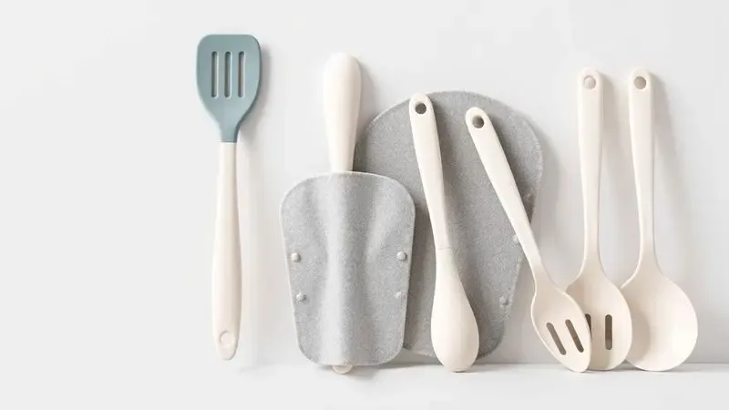 Exposição organizada de utensílios de silicone e protetores de tecido para conservação de panelas.